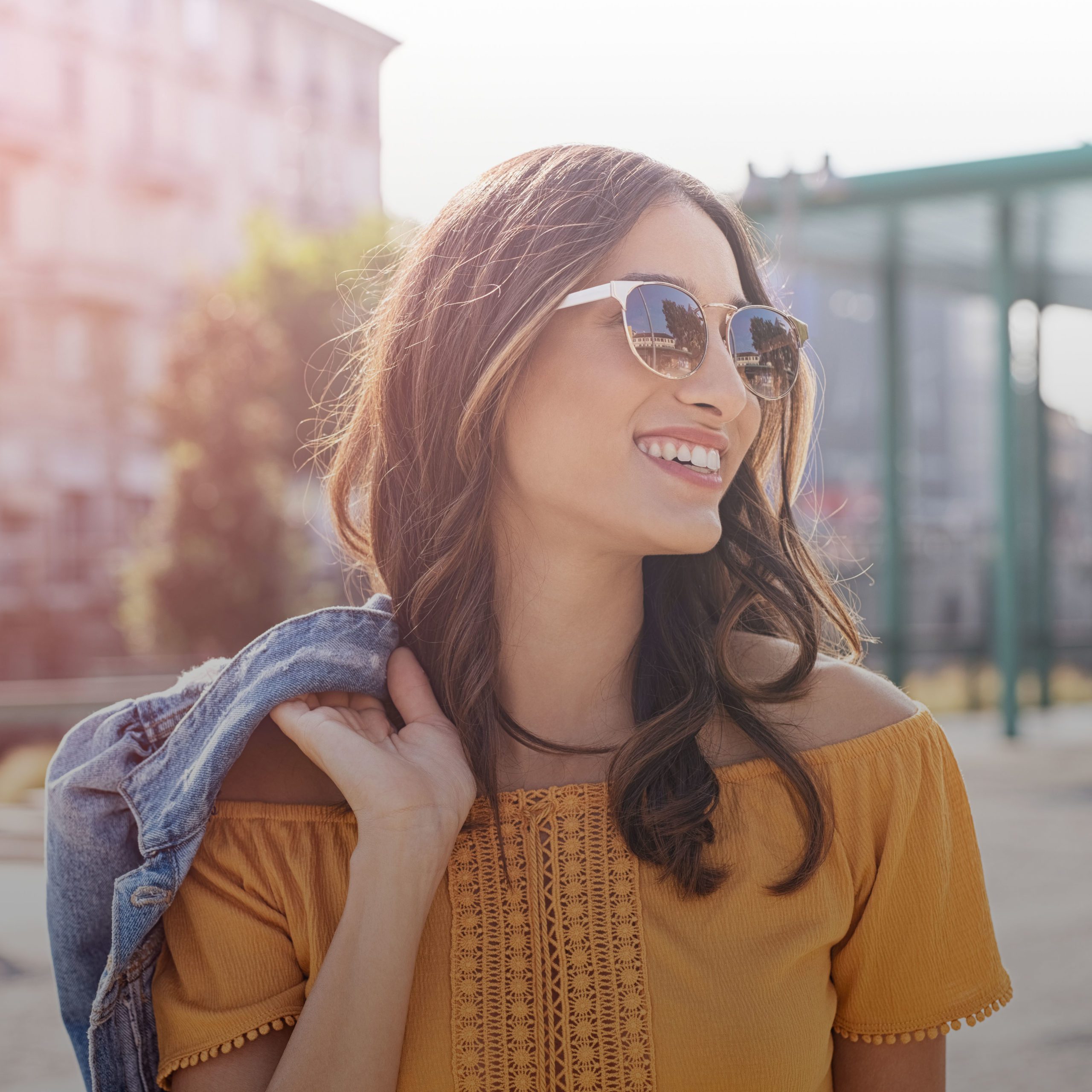Happy latin woman walking on the street on a bright sunny day. C